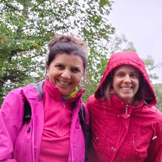 Uta und Caro Weinig im Regen mit Regenkleidung in Rot und Pink.